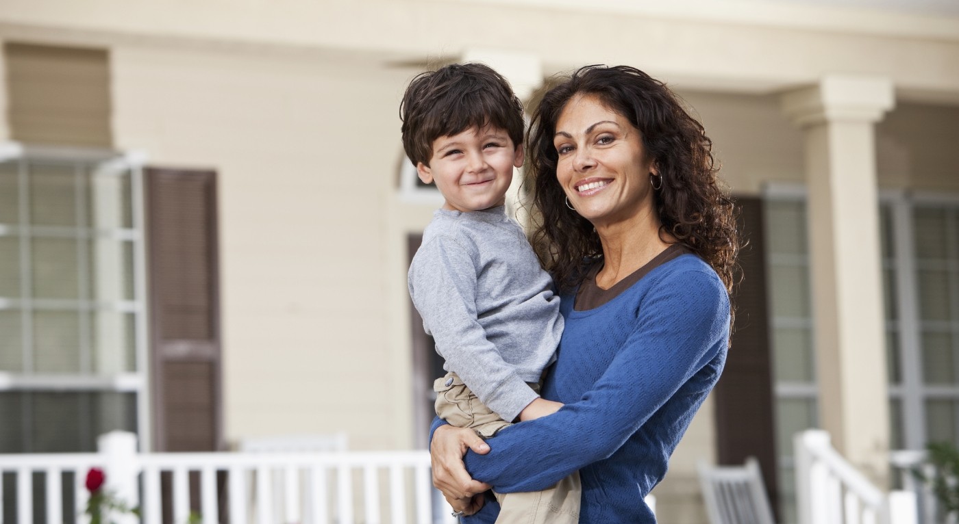 Mother holding smiling child after preventive dentistry visit