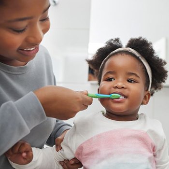 Mother brushing her child’s teeth