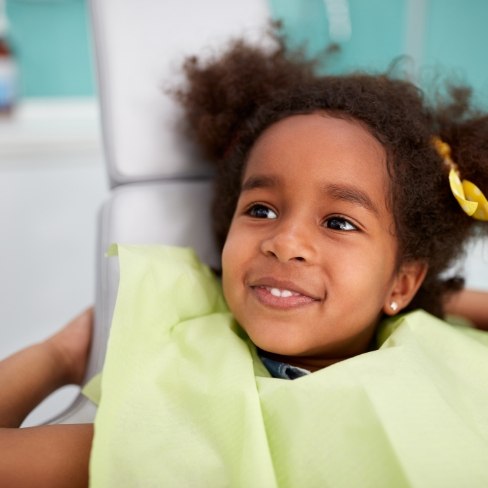Child smiling during treatment for dental emergency