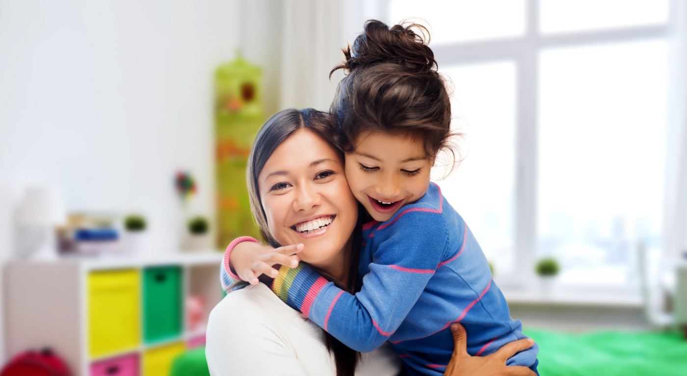 Mother and child smiling together after tooth extractions