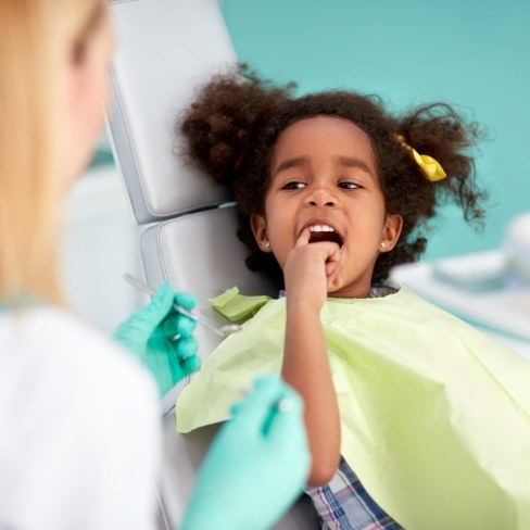 Child pointing to tooth before extraction