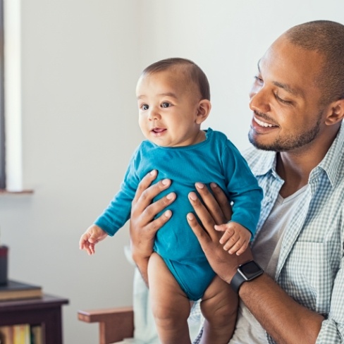 Smiling father and baby after dentistry for infants