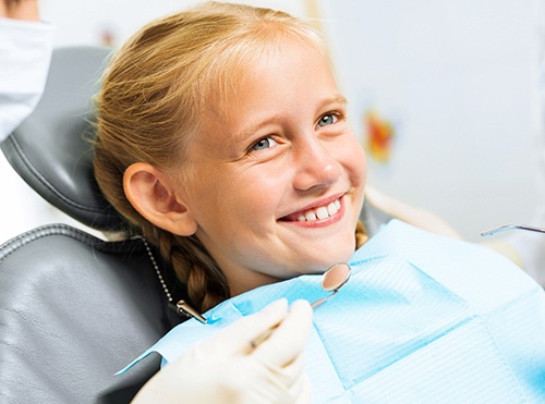 smiling blonde child in the dental chair