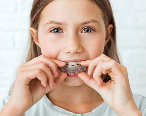 Child placing custom mouthguard