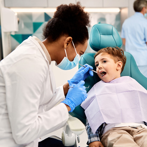 Dentist examining child’s mouth