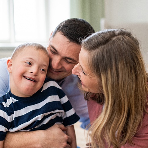 young boy with Down Syndrome with parents
