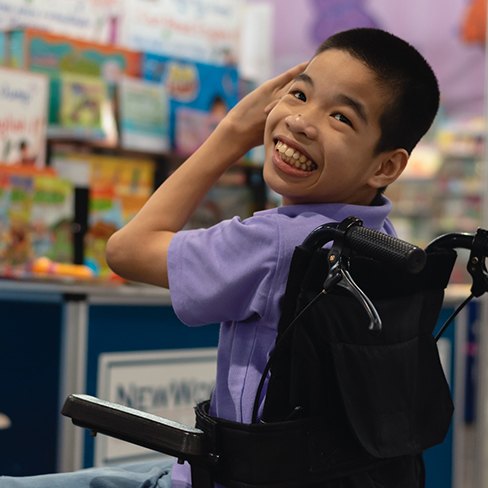 young boy in wheelchair smiling