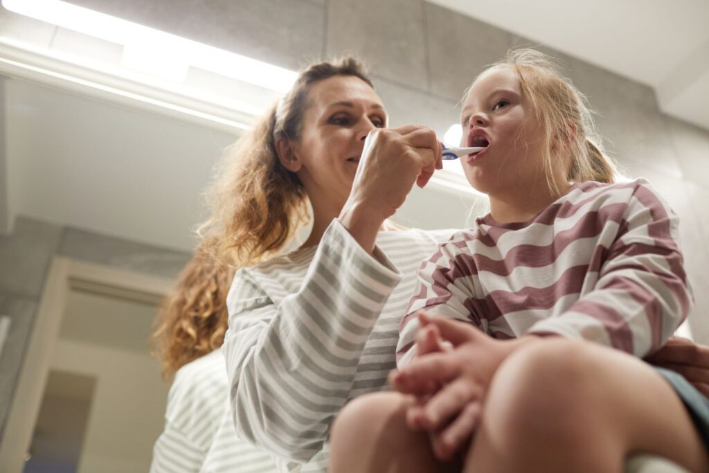 A woman brushing her daughter’s teeth